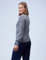 Buzo tejido en hilado fino, color gris, con cuello redondo y mangas largas plisadas.