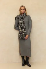 Vestido largo de punto color gris, con cuello alto, mangas largas y aberturas laterales en el ruedo.