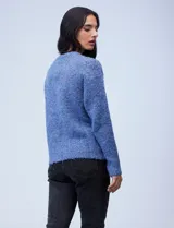 Buzo de lana melange color tostado, con cuello redondo y mangas largas.