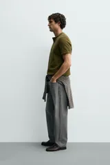 Camiseta de manga corta con cuello panadero y cierre frontal de tres botones. Presenta una textura acanalada y un corte regular fit.