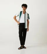 Pantalón masculino de corte slim cropped, confeccionado en viscosa con cintura elástica, bolsillos laterales y traseros, y pliegues delanteros.