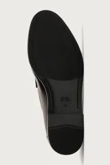 Mocasín de vestir negro de estilo clásico con detalle de antifaz en la parte superior, suela a tono y ligero tacón.