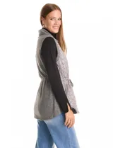 Chaleco gris de diseño híbrido, con frente capitoneado de patrón ondulado y espalda de tejido de punto. Presenta cuello con solapa, cierre frontal con botones a presión metálicos, cordón de ajuste en la cintura y bajo curvo.