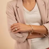 Brazalete tipo esclava de alambre redondo en plata 925, con dije de medalla circular colgante.