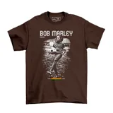 Remera marrón de manga corta con estampa frontal en blanco y negro de Bob Marley jugando al fútbol, acompañada de texto y detalles en colores verde, amarillo y rojo.