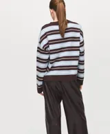 Sweater de punto fino con diseño oversize y patrón de rayas horizontales en tonos marrón, celeste y blanco. Cuenta con cuello redondo y mangas largas.