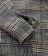 Campera tipo bomber de polivelour con estampado de cuadros, cuello inglés, cierre frontal, mangas largas y bolsillos funcionales.