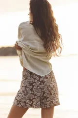 Short de tiro alto con detalle de nudo delantero y bordados florales perforados.