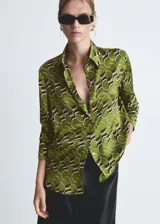 Camisa de mangas largas con puños abotonados, de tejido satinado con estampado geométrico en tonos verde, marrón y blanco.