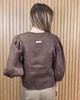 Camisa de cuello redondo y manga larga abullonada, con diseño a rayas en tonos rosado y blanco.