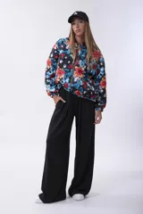 Campera bomber acolchada con cierre frontal, diseño estampado floral multicolor sobre base negra, cuello, puños y ruedo elásticos.