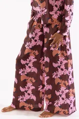 Pantalón ancho de corte fluido con estampado floral en tonos marrones y rosados, confeccionado en mezcla de viscosa y poliamida, con bolsillos laterales y elástico en la cintura.
