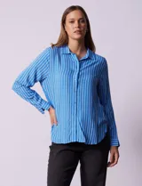 Camisa celeste con rayas verticales blancas, de corte clásico, cuello a la base, escote en V y abertura central con botones.