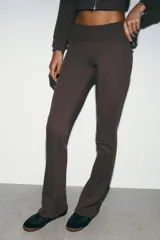Pantalón de felpa marrón, de tiro alto con cintura elástica y diseño flare acampanado en las pantorrillas.