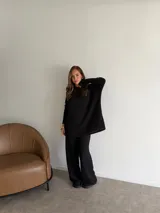 Buzo de cuello redondo y manga larga, confeccionado en tejido de viscosa con textura acanalada en color marrón chocolate. Presenta un corte holgado y relajado.