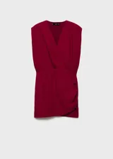 Vestido corto rojo con escote en V cruzado, sin mangas y con detalle drapeado en la falda.
