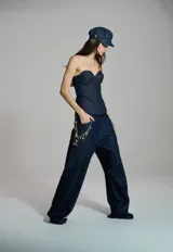 Corset de denim azul oscuro con diseño strapless, escote corazón y costuras pespunteadas que estructuran la prenda.