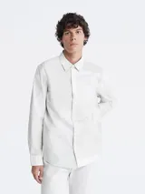 Camisa blanca de manga larga con cuello clásico y cierre con botones.