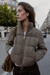 Anorak estilo bomber con diseño acolchado y tejido de punto con textura. Presenta cuello subido, cierre frontal con cremallera, mangas largas con elástico interior y bolsillos delanteros de vivo con forro polar. El bajo cuenta con acabado elástico.