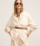 Campera oversized color beige con capucha ajustable, cierre frontal con cremallera, bolsillos cargo delanteros y puños con pliegues.