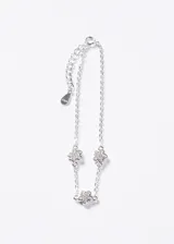 Pulsera de plata 925 con cadena eslabonada y tres dijes en forma de flor cubiertos de zirconias, con cadena de extensión.
