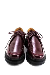 Zapatos tipo wallabee de cuero metalizado en tono peltre, con cordones negros y suela track de goma negra con plataforma.