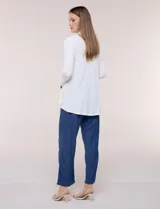 Cárdigan liviano blanco de punto acanalado, confeccionado en viscosa y elastano, con diseño de frente abierto, mangas largas entalladas y silueta fluida.