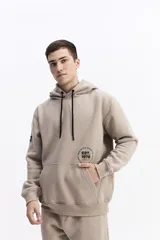 Canguro con capucha y cordones ajustables en color beige, con diseño de calce regular y estampado frontal pequeño.