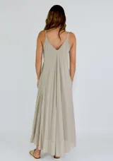 Vestido largo blanco de tirantes finos, con escote en V profundo y detalle de volados en el frente. Diseño fluido y ligero.