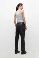 Pantalón de eco cuero negro, de corte recto, con tachas plateadas en los bolsillos delanteros.