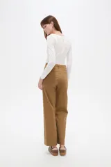 Pantalón de algodón color blanco, de tiro alto y corte flare, con bolsillos y detalles de vivos.