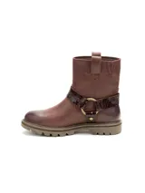Bota de cuero color marrón con diseño tipo arnés, con detalle de correa con textura reptil y herrajes metálicos. Cuenta con suela de goma con tacos y construcción robusta.