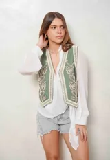 Chaleco verde militar con bordados en la parte delantera y apliques de perlas.