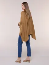 Poncho de calce holgado color marrón, confeccionado en tejido fino de punto suave, con cuello redondo y diseño de caídas laterales amplias de ruedo asimétrico.