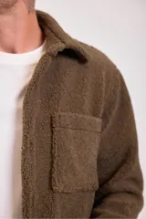Campera marrón de borreguito con cuello camisero, cierre con botones a presión y bolsillo de parche en el pecho.