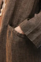 Tapado oversize largo midi, color gris con textura de microcuadrillé, cuello con solapa, cierre frontal con botones, bolsillos con tapa y hombros caídos.