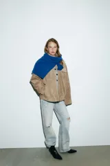 Botín de tacón kitten en acabado charol negro, con diseño de punta fina y cierre lateral mediante cremallera.