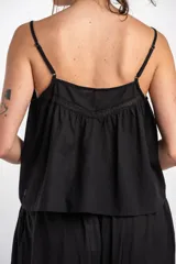 Blusa de algodón peinado color negro, con tirantes finos, escote en V y detalles de bordados y encaje en el frente.