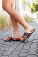 Sandalias bajas de cuero marrón con tres tiras: una de cuero marrón, una de cuero liso color visón y una de cuero con estampado animal print.