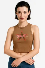 Musculosa de algodón color marrón, con cuello redondo a la base y corte al cuerpo. Presenta un estampado frontal en forma de estrella con diseño de animal print y la palabra 'STARGIRL' en letras blancas con borde rojo.