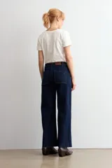 Jean culotte de tiro alto y corte recto, confeccionado en denim de color azul oscuro. Presenta costuras en contraste y un diseño de pierna ancha con ruedo desflecado.