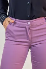 Pantalón de corte chupín en color violeta, con bolsillos delanteros funcionales y falsos bolsillos traseros. Presenta cierre frontal con botón y costuras reforzadas.