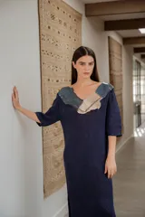 Vestido largo azul con cuello con apliques de cuero y flecos en el ruedo.