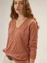 Buzo de tejido en lurex con escote en V, manga larga y silueta relajada, con un brillo sutil y textura tramada.