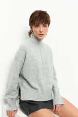 Polera de tejido de punto color bordó, con cuello alto, manga larga y costura vertical central en el frente.