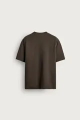 Remera blanca de corte relajado, con cuello redondo y mangas cortas.