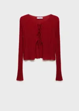 Cardigan de punto fino color rojo, con diseño corto, cuello redondo y manga larga. Presenta un cierre frontal mediante múltiples lazos finos.