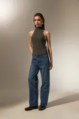 Top tejido de punto color gris oscuro con cuello alto tipo polera y diseño sin mangas con corte halter.