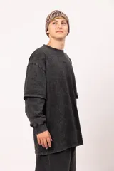 Buzo de manga larga con efecto de doble manga superpuesta, confeccionado en jersey de algodón con proceso de lavado gastado. Presenta un corte oversized y bordado de la marca en el centro del pecho.