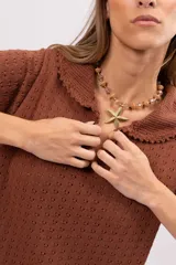 Vestido corto marrón de punto calado con cuello polo y mangas cortas.